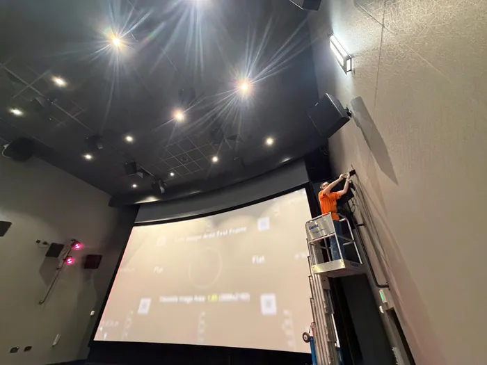 Cinema-style screening room with crew testing the projection screen