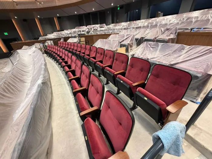 Theater seating with a cleaning cloth draped on the armrest